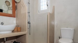 A bathroom with a sink, mirror, shower, and toilet. - Charming little villa Elena with private pool and sea views! (Paros)