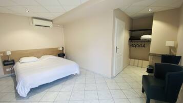 Une chambre d’hôtel équipée d’un lit, d’une chaise, d’un bureau et d’un appareil de climatisation.
