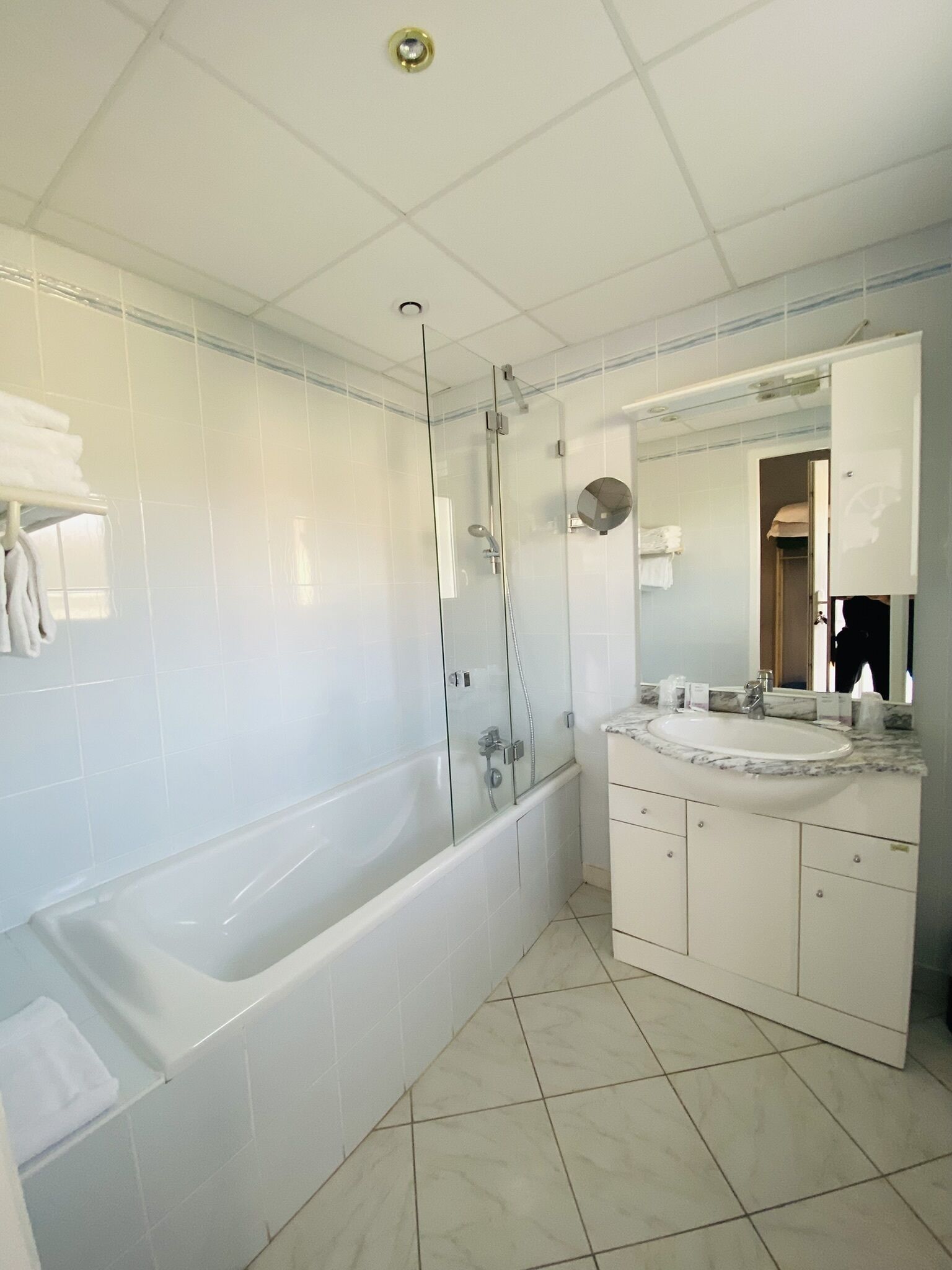 A modern bathroom with a glass-enclosed shower, a freestanding bathtub, and a vanity with a sink and mirror.