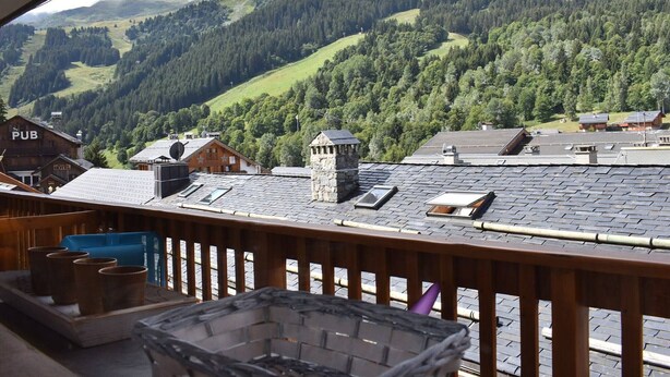 A balcony with a view of a mountainous landscape, a pub, and a hotel. - Charming Studio for 4 in Meribel, Near Slopes and Shops (Méribel)