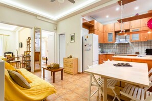 A compact living space with a dining area, kitchenette, and a sofa.