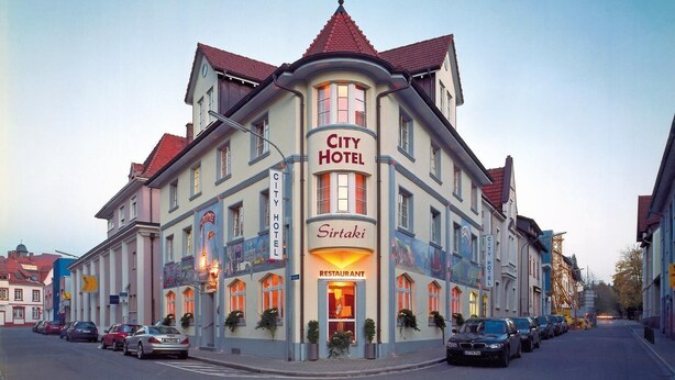 Ett stadshotell med en restaurang på bottenvåningen, flera våningar och en klassisk arkitektonisk stil.