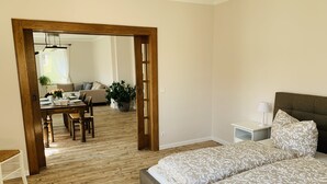 Une chambre avec un grand lit, une table de chevet et un plancher en bois.