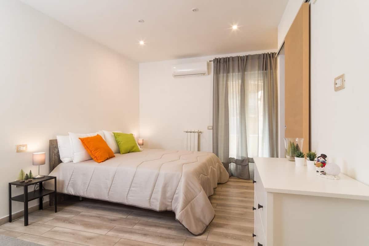 A bedroom with a bed, bedside table, and a dresser.