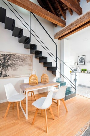 A modern kitchen with white cabinets, a wooden countertop, and a built-in oven.