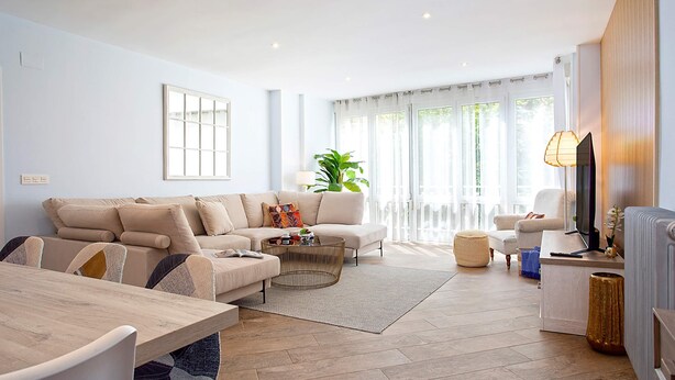Una sala moderna con un conjunto de sofás, una mesa de centro y un televisor.