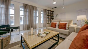 A modern living room with a sofa, coffee table, and a bookshelf. - Genteel Home Tomás de Ibarra (Seville)