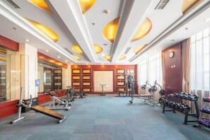 A gym with exercise equipment, large windows, and a modern ceiling design.