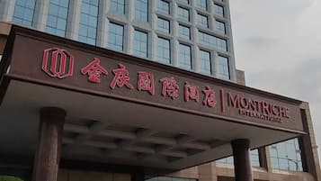 A hotel entrance with a sign in Chinese and English, indicating it is a Montriché International hotel.