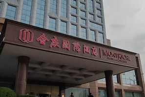 L’entrée d’un hôtel, avec une enseigne en chinois et en anglais, indiquant qu’il s’agit d’un hôtel Montriché International.