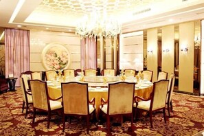 A dining area with a round table, chairs, and a chandelier. - Montriche International Hotel (WEIFANG)