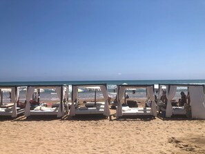 En la playa, sillas reclinables de playa, toallas de playa