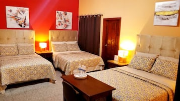 Habitación de hotel con dos camas, una mesita y obras de arte en las paredes.