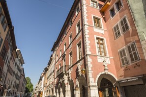 Un immeuble à plusieurs étages, de style architectural classique, caractérisé par des fenêtres en arc de cercle et des balcons.