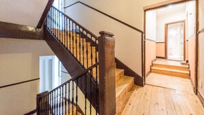 Un escalier en bois avec des rampes noires menant à l’étage supérieur.