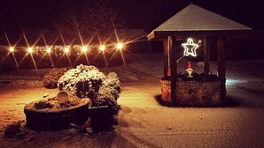 A snow-covered outdoor area with a small gazebo featuring a star decoration and a gnome figure. - Apartment in the beautiful biosphere reserve on Rügen (Lancken-Granitz, Rügen)