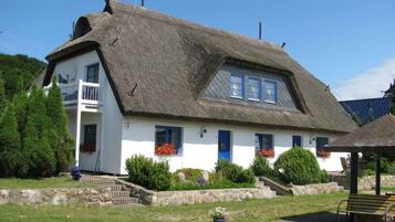 Traditional cottage with a balcony and garden, offering a peaceful retreat.