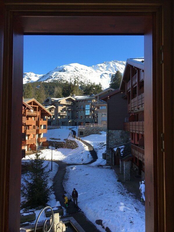 A view of a snow-covered mountain town with buildings and a ski slope.