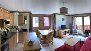 A compact living space with a kitchen, dining area, and a living room with a sofa and chairs. - B205 - 58 m2 - 3P - 6 pers (Prapoutel)