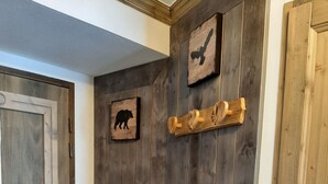 A wooden door with a rustic design, a small animal picture, and a wooden shelf with a decorative item. - F101 - 40 m2 - 2P - 2/4 pers (Prapoutel)