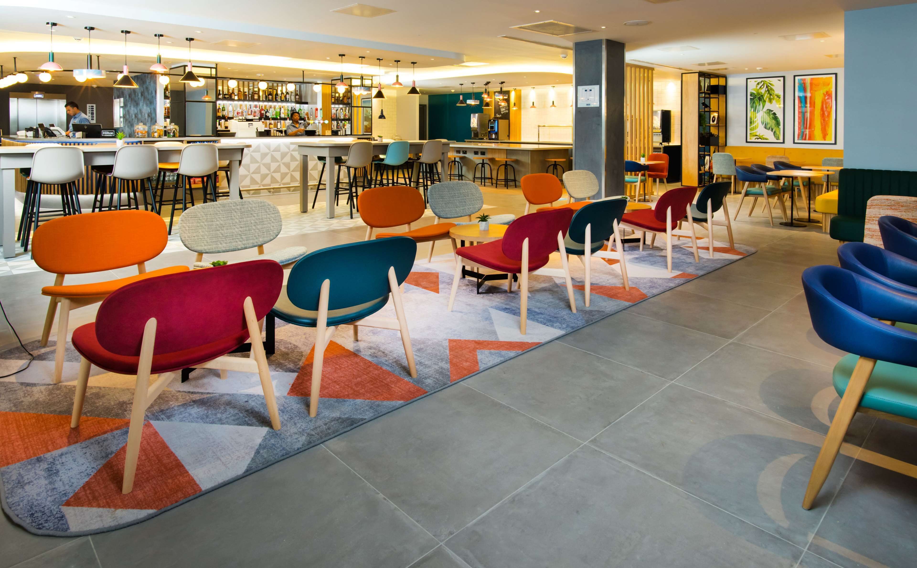 Un área de bar moderna con diferentes opciones de asientos y una barra.