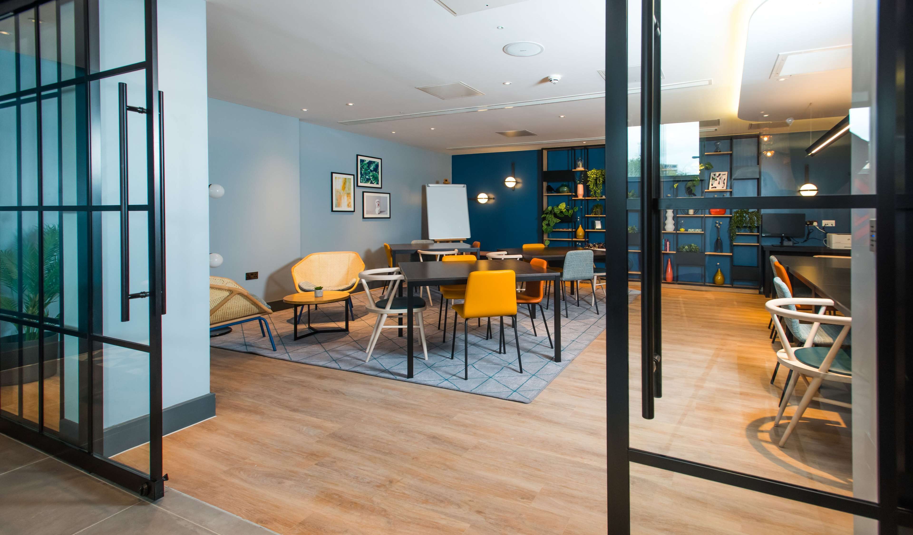 Een moderne kantoorruimte met een vergadertafel, stoelen en een whiteboard.