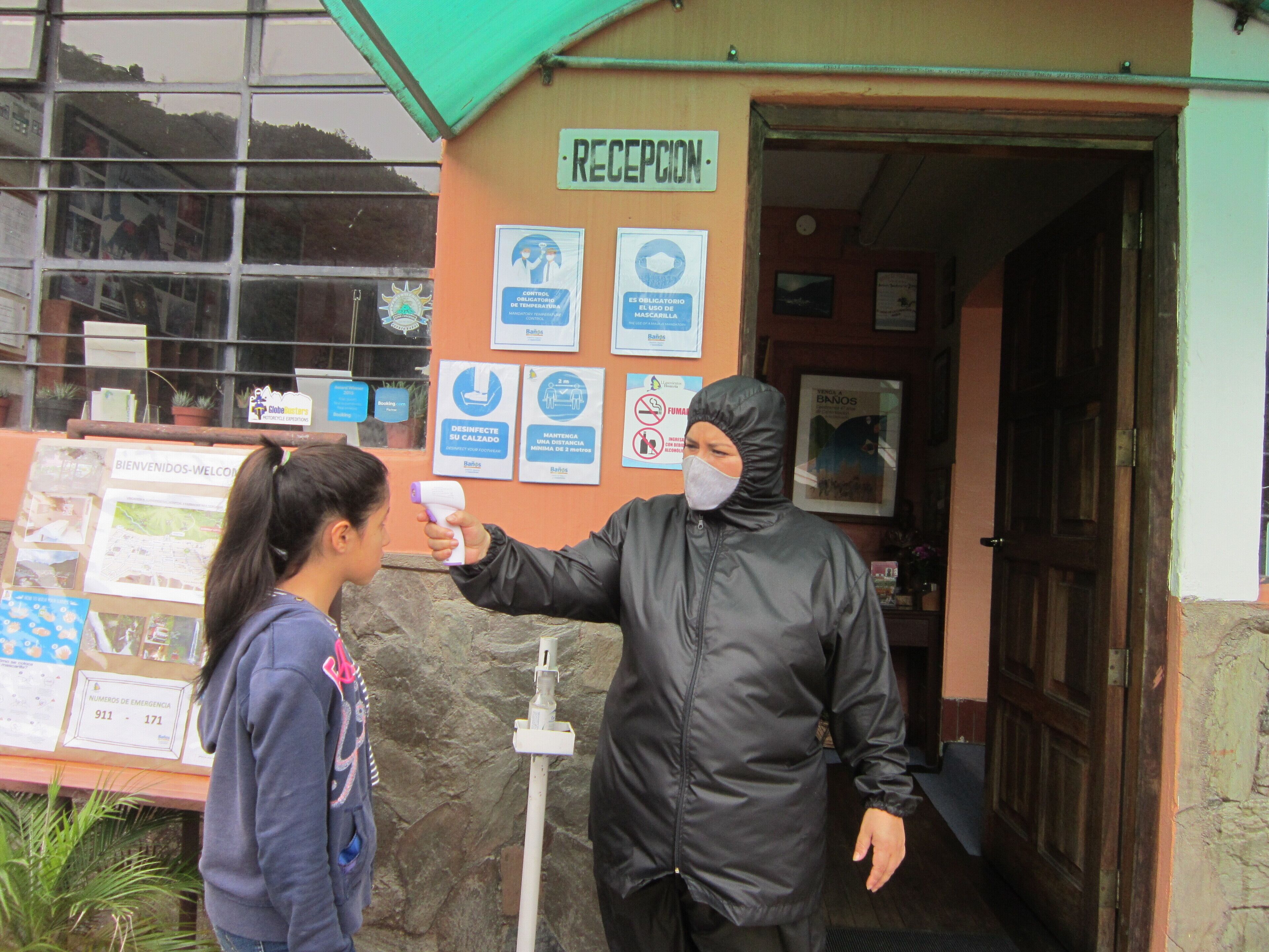 A reception area with a sign reading "RECEPCION" and various informational posters on the wall.