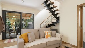 Un salon avec un canapé, une table basse et un escalier.