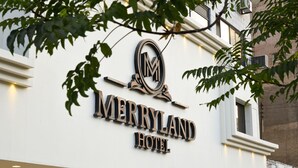 A hotel sign with a prominent 'M' logo and the name 'MERRYLAND HOTEL' in bold letters. - New MerryLand Hotel (Amman)