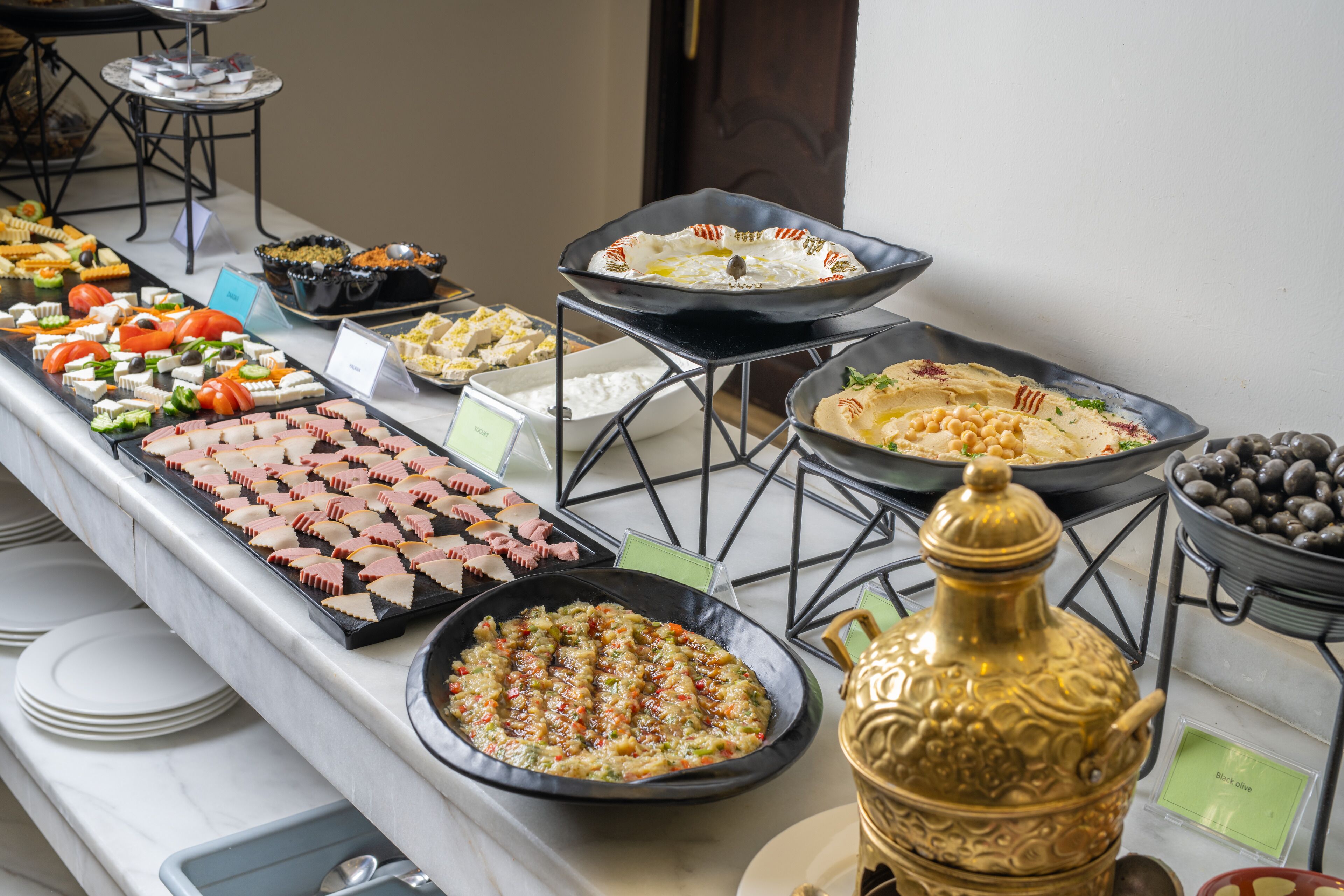 A buffet with various food items and a decorative golden urn.