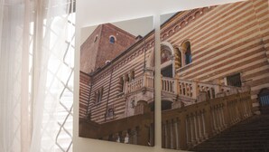 Un mur orné de deux photographies encadrées représentant un bâtiment historique, avec des arcades et un escalier.