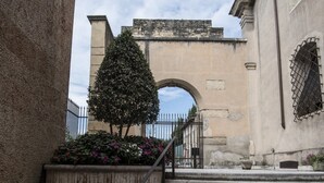 Un escalier en pierre menant à un bâtiment doté d’une entrée en arc de cercle.