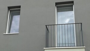 A building facade with two windows and a balcony with a metal railing. - AdagioRooms (Elmas)