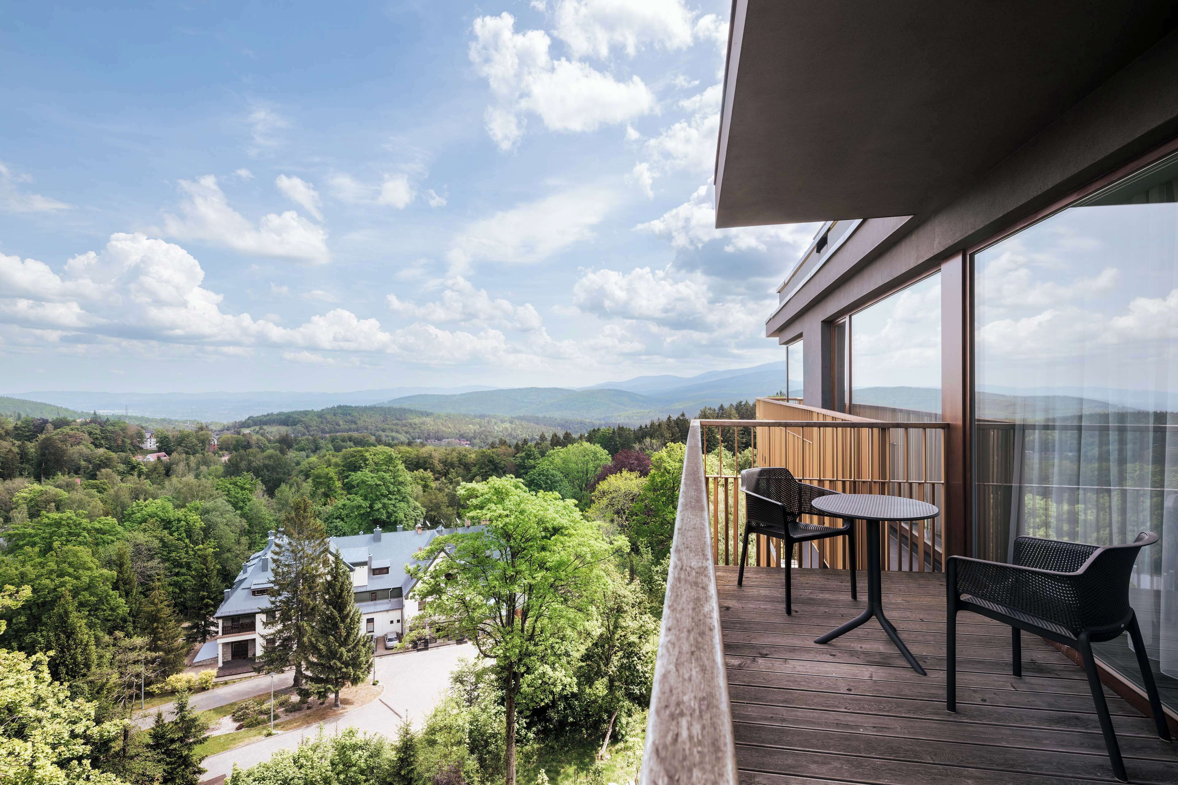 Ein Balkon mit Blick auf ein bewaldetes Tal und Berge.