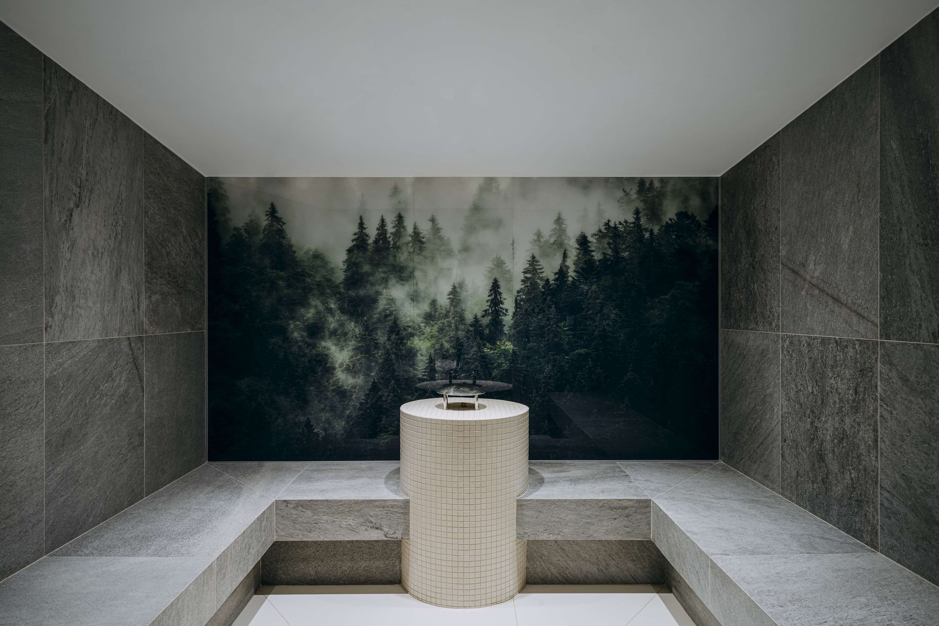 A modern bathroom with a large, grid-patterned sink, a bench, and a forest-themed mural on the wall.