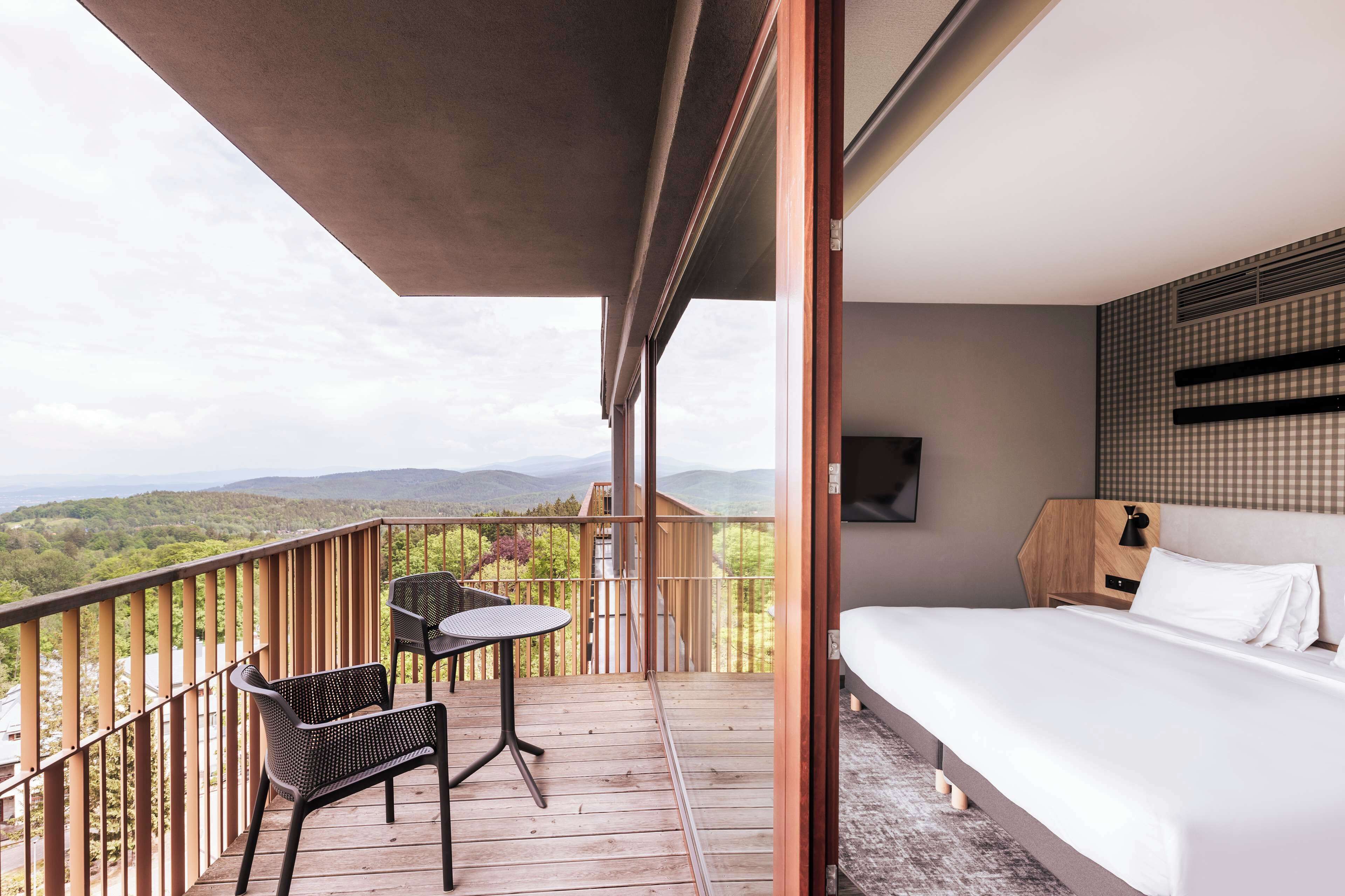 A balcony with a bed, a table, and two chairs.