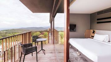 A balcony with a bed, a table, and two chairs.
