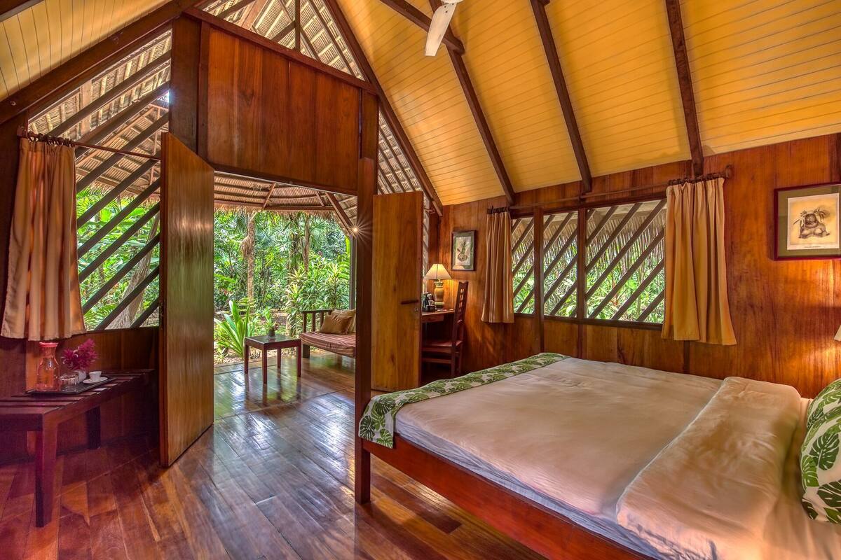 Une pièce en bois avec un lit, un bureau et une chaise.