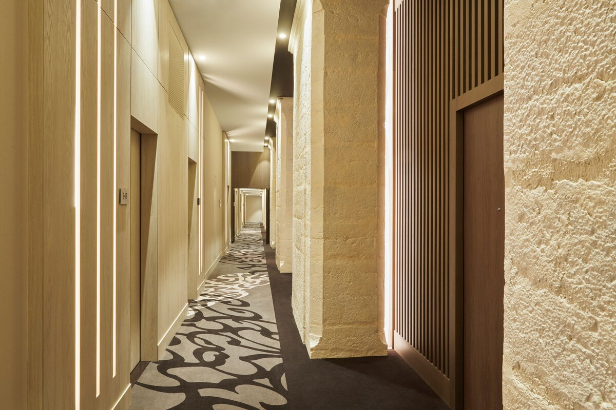 A long, narrow hallway with wooden paneling and a patterned carpet.