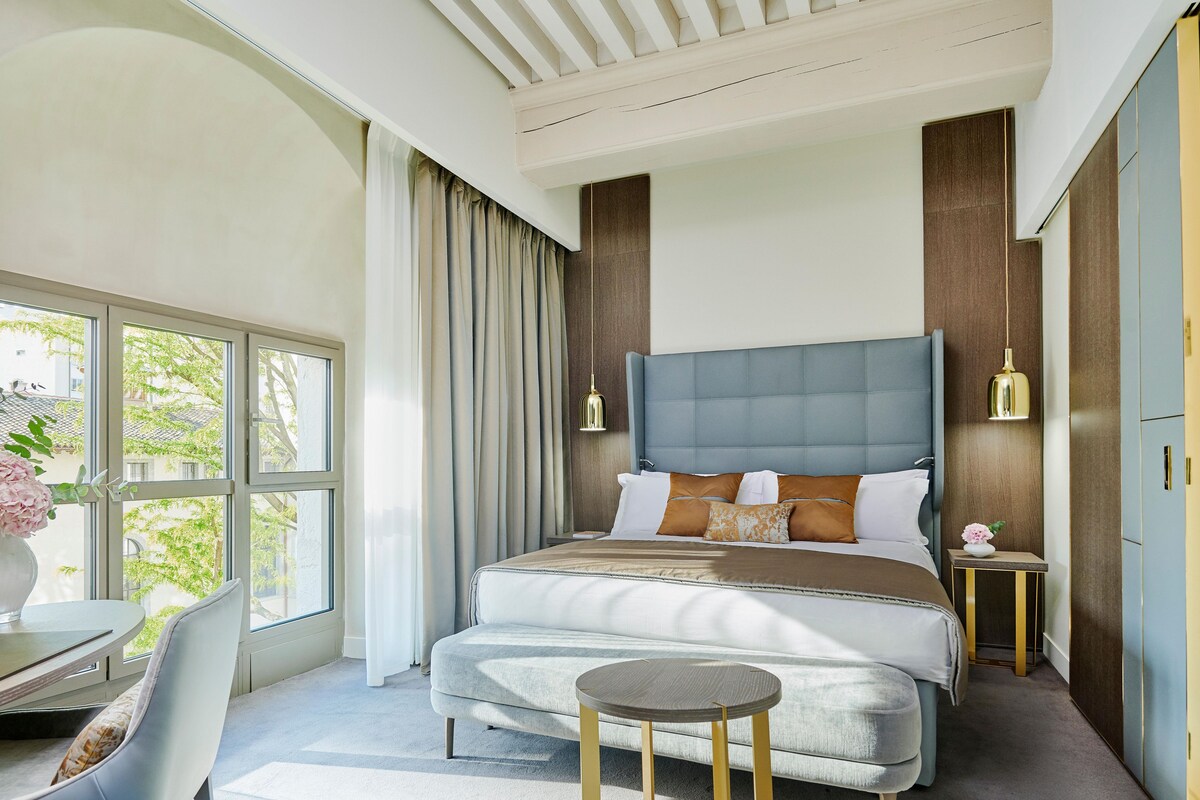 Un dormitorio moderno con una cama grande, un escritorio y una silla.