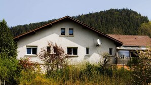A two-story building with a sloped roof, multiple windows, and satellite dishes. - La Chti Cabane (Taintrux)