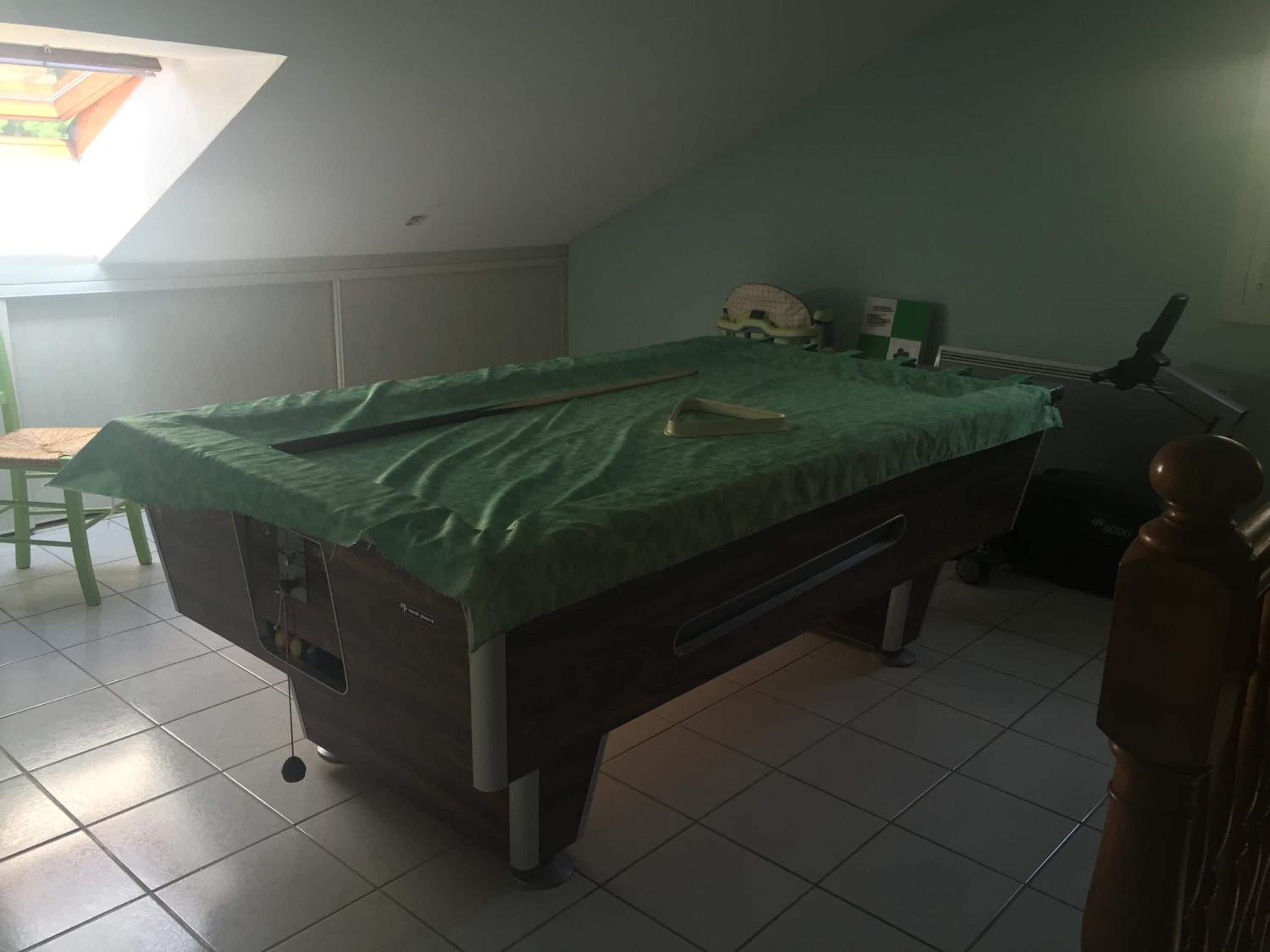 A medical examination room with a bed, examination table, and medical equipment.