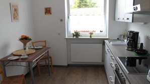 Una cocina compacta con una mesa, sillas y una ventana con vistas.