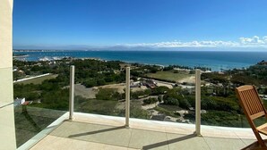 Ein Balkon mit freiem Blick auf das Meer und ferne Berge.