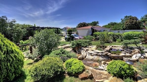 A well-maintained garden with various plants and a stone feature. - Apartment with pool, air conditioning, WLAN, barbecue (Pula)