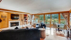 A spacious living room with a fireplace, large windows, and a cozy seating area. - Spacious Remodel, 4br, Minutes To Conf Center & Slopes! 4 Bedroom Condo by RedAwning (Keystone)