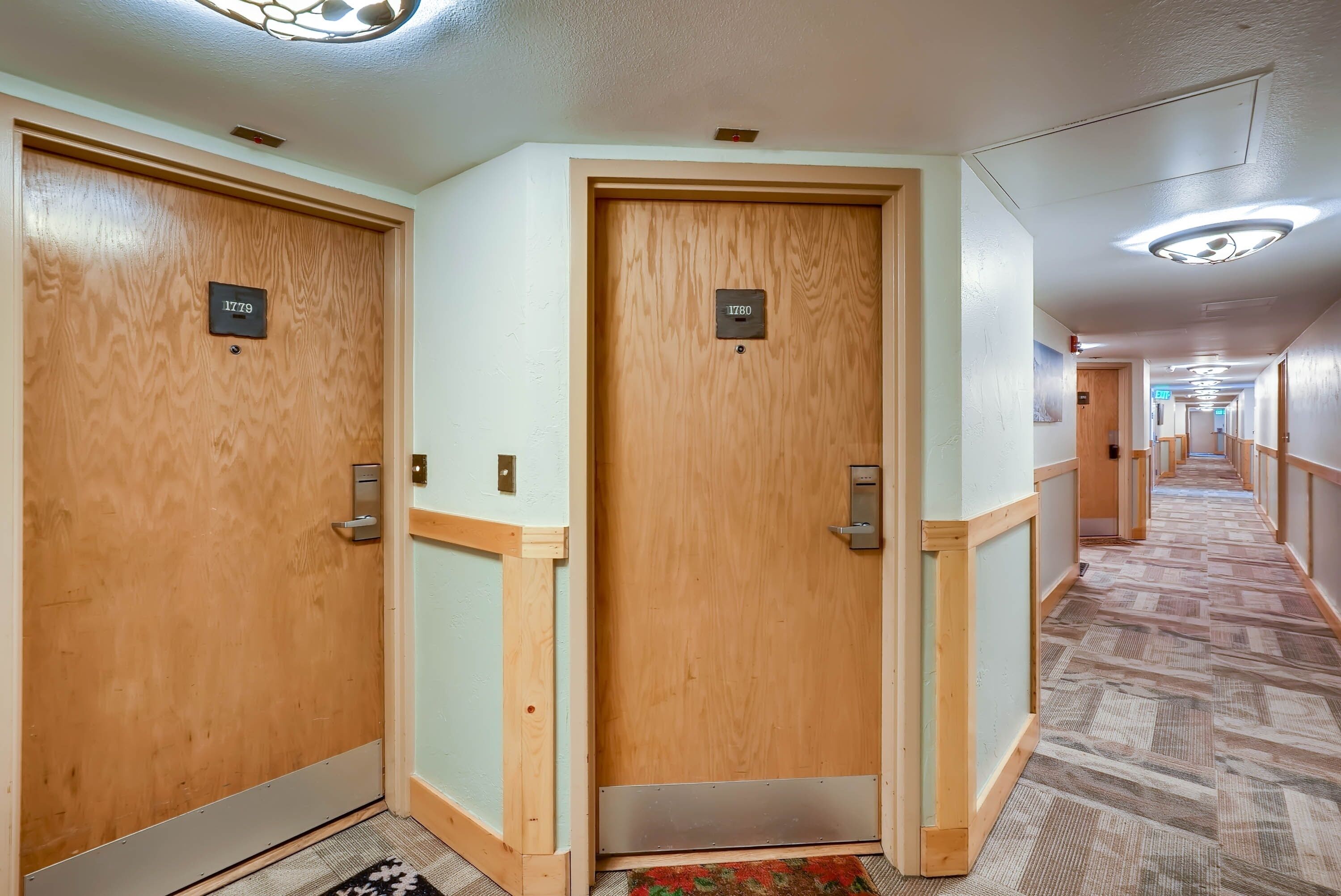 Un pasillo de hotel con puertas de madera, cada una con un número.