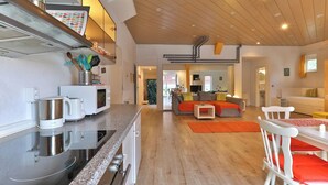 A modern kitchen with stainless steel appliances, a dining area with a table and chairs, and a living room with a sofa and a coffee table. - Nürtingen: spacious loft-style apartment between orchards and Neckar (Nürtingen)