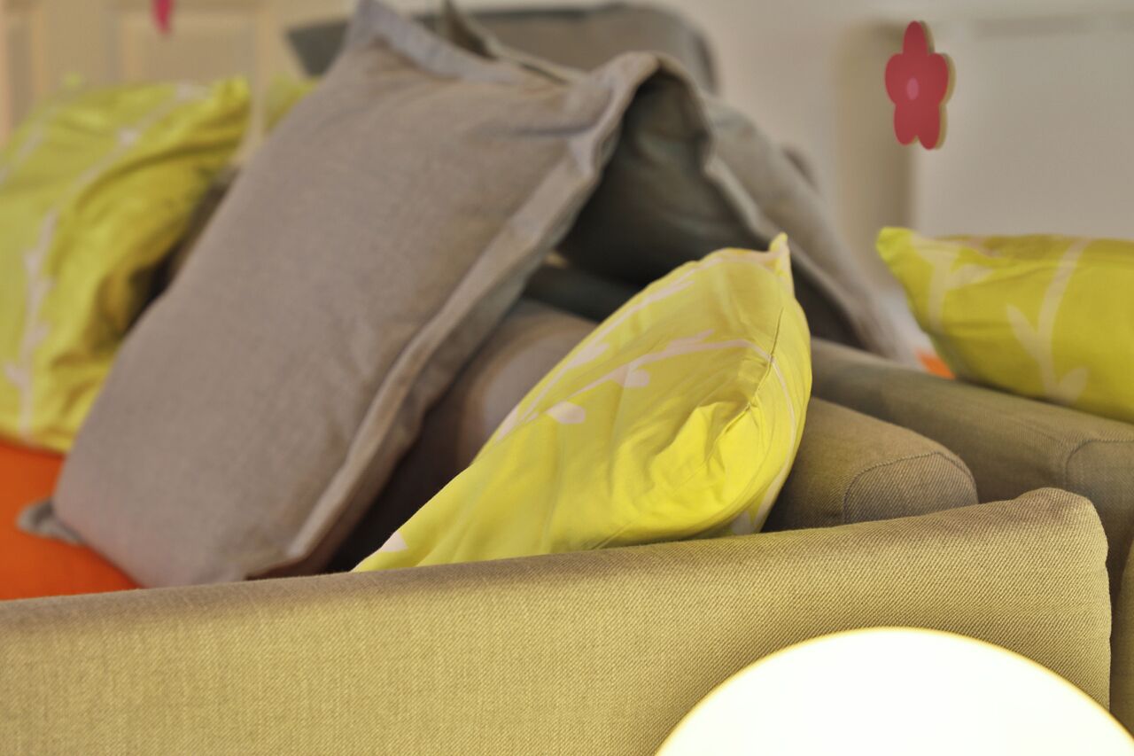 A close-up of a sofa with multiple cushions in various colors.