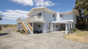 Ein zweistöckiges Haus mit Balkon, Treppe und Garage.